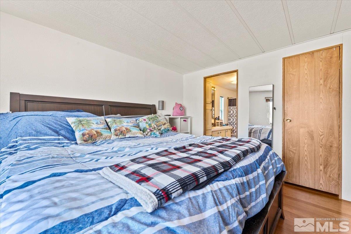 3867 Puffin Street Reno, NV 89508 - Photo 19 of 29 a bedroom with a bed and wooden floor