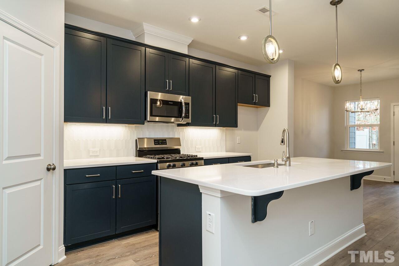 3113 Dunnock Drive, Unit 3 Durham, NC 27713 - Photo 12 of 30 a kitchen with a sink a microwave a stove and refrigerator