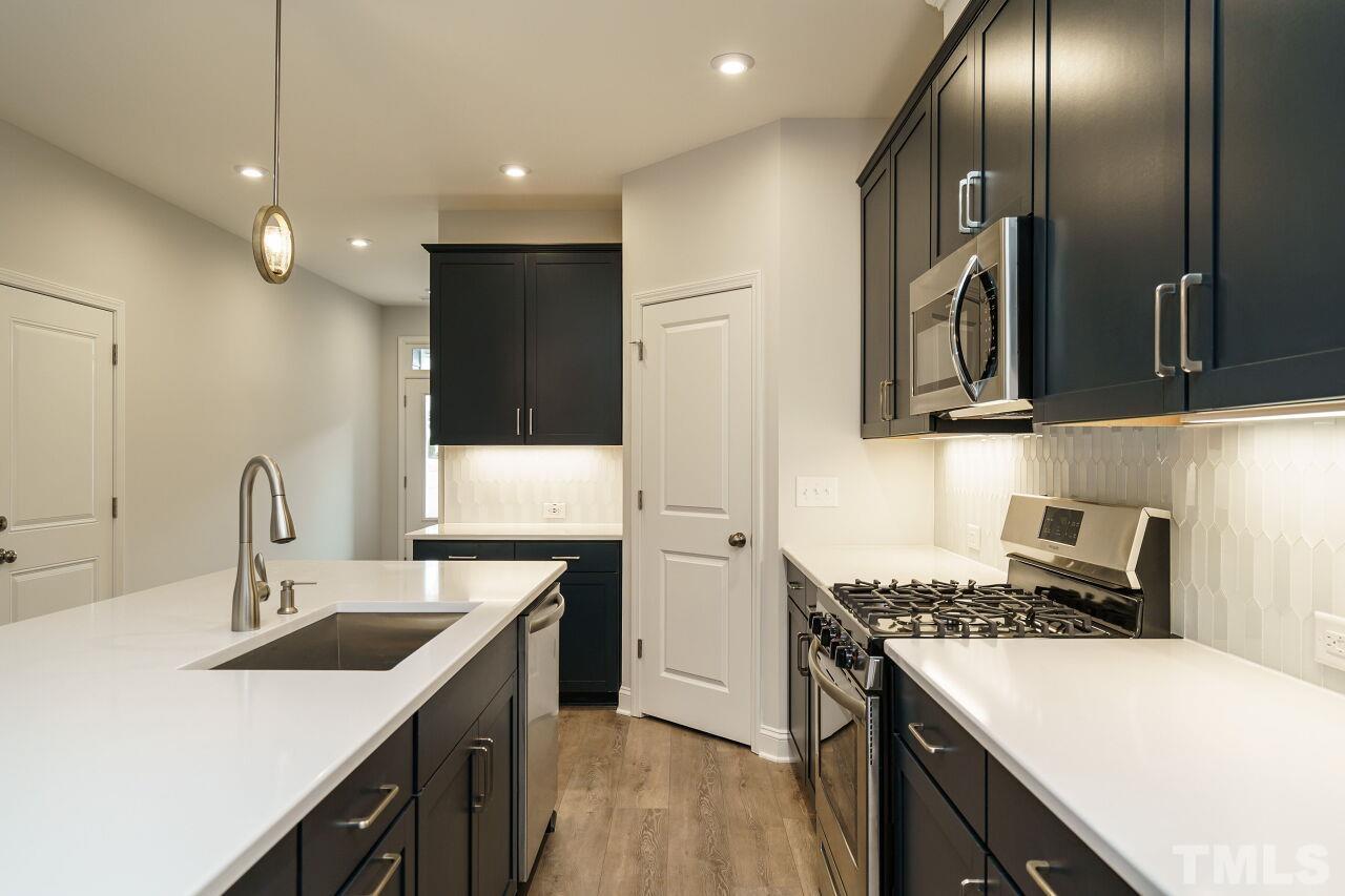 3113 Dunnock Drive, Unit 3 Durham, NC 27713 - Photo 13 of 30 a kitchen with a sink a stove and refrigerator