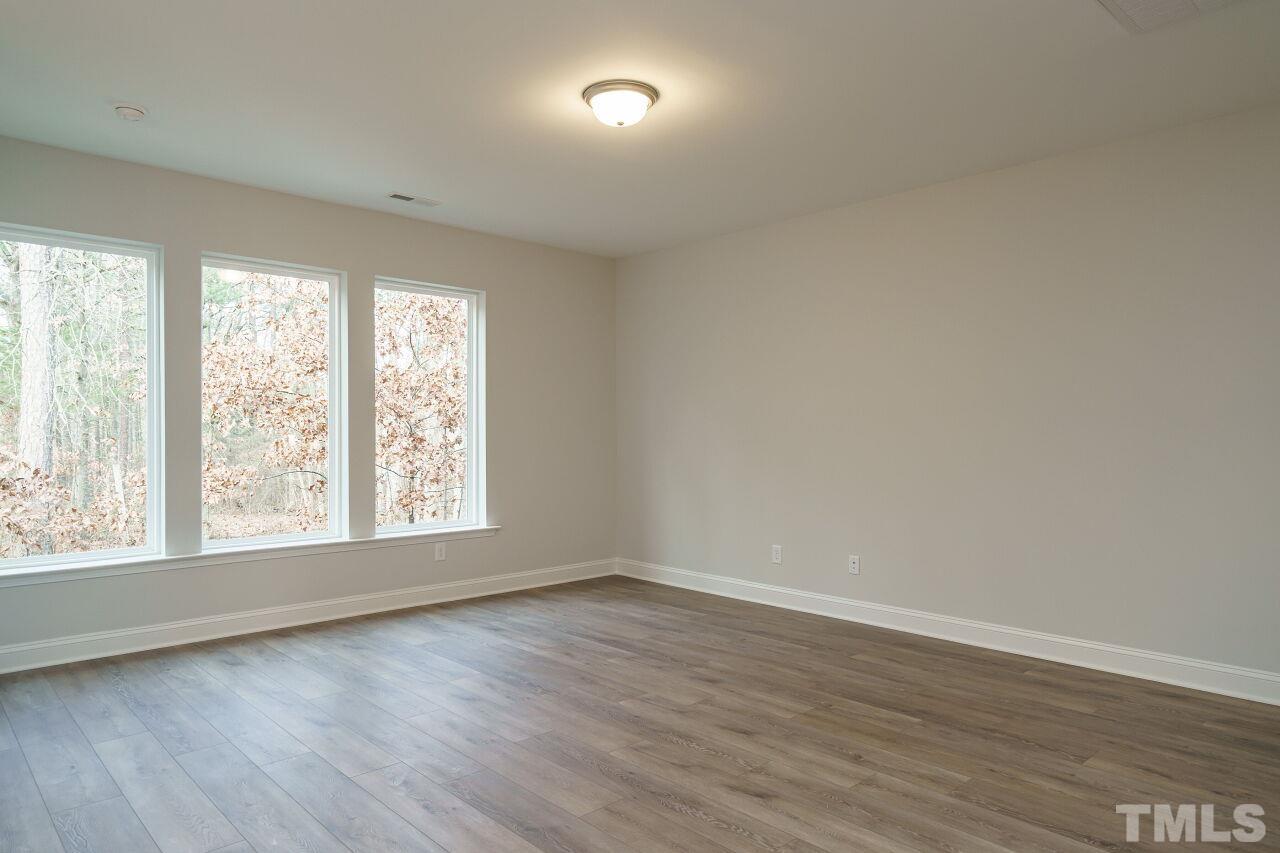 3113 Dunnock Drive, Unit 3 Durham, NC 27713 - Photo 5 of 30 an empty room with wooden floor and windows