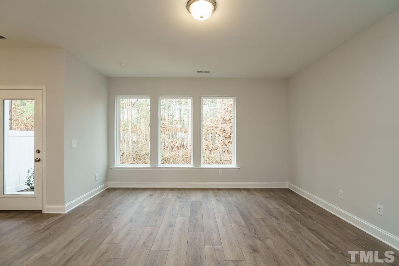 3113 Dunnock Drive, Unit 3 Durham, NC 27713 - Photo 8 of 30 an empty room with wooden floor and windows