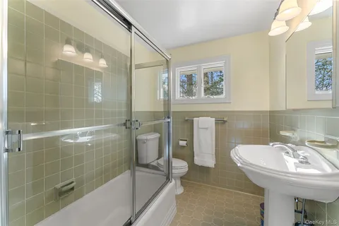 a bathroom with a sink shower and a mirror