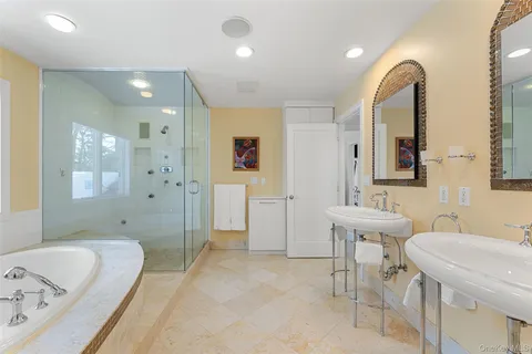 a spacious bathroom with a tub sink and mirror