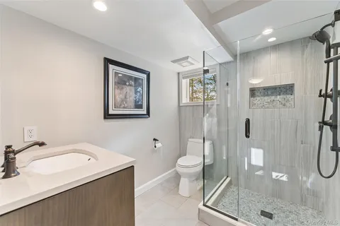 a bathroom with a granite countertop sink toilet and shower