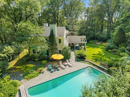 a view of a backyard with table and chairs under an umbrella