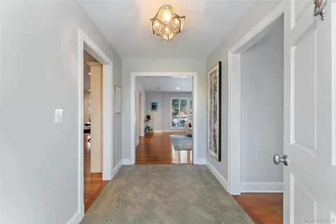 a view of a hallway with a livingroom and a chandelier fan