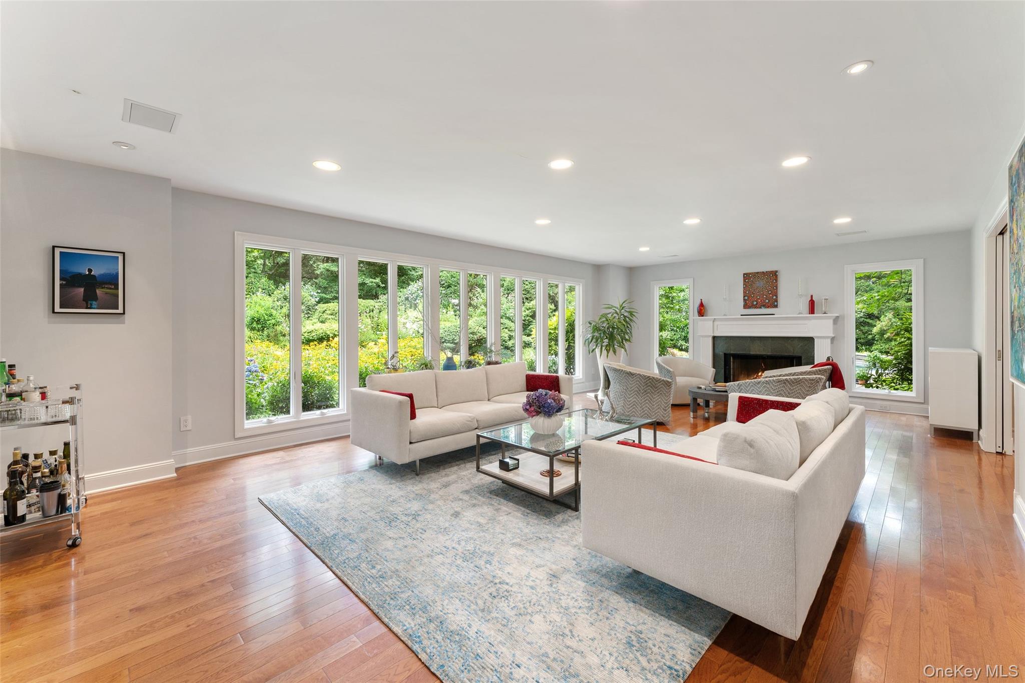 110 Round Hill Road Scarsdale, NY 10583 - Photo 7 of 48 Living room with floor to ceiling windows and wood burning fireplace