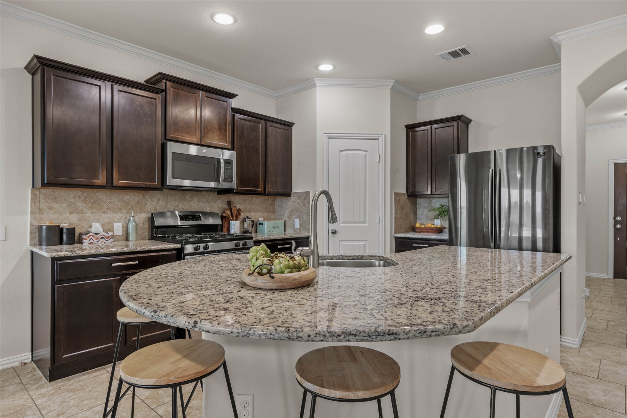 536 Rancho Verde Drive Leander, TX 78641 - Photo 5 of 37 a kitchen with granite countertop stainless steel appliances a refrigerator a stove a sink a dining table and chairs