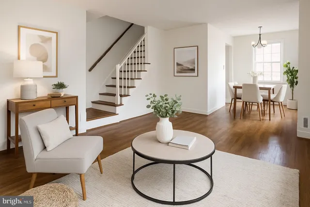 a dining room with furniture a potted plant and wooden floor