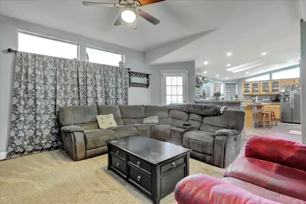 a kitchen with stainless steel appliances granite countertop a sink a stove a refrigerator and island with wooden floor