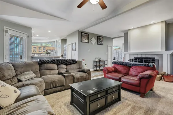 a kitchen with stainless steel appliances granite countertop a stove top oven a sink dishwasher and a microwave oven with large trees