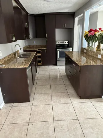 a kitchen with stainless steel appliances granite countertop a sink counter space and cabinets