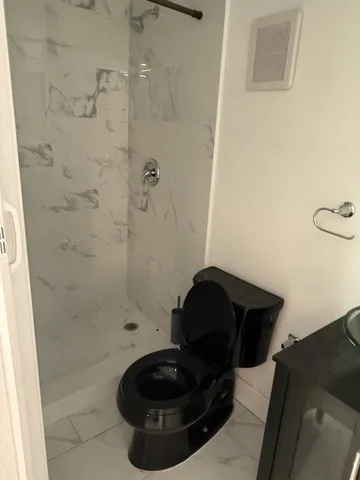 a bathroom with a toilet and a shower
