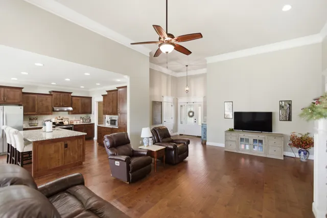 a living room with furniture kitchen view and a flat screen tv