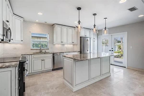 a kitchen that has a lot of cabinets in it and appliances