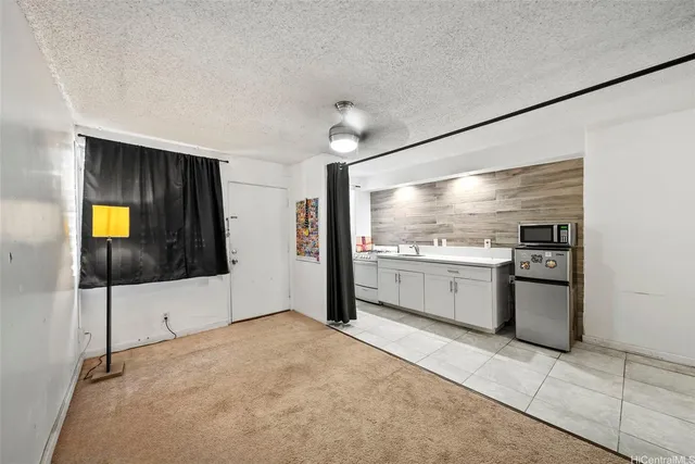 a view of open kitchen with a sink and refrigerator