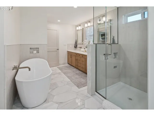 a bathroom with a bathtub a shower a sink and mirror