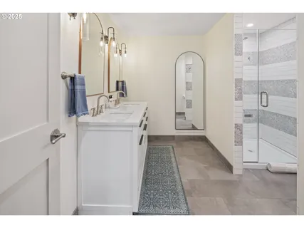 a bathroom with a double vanity sink mirror and shower