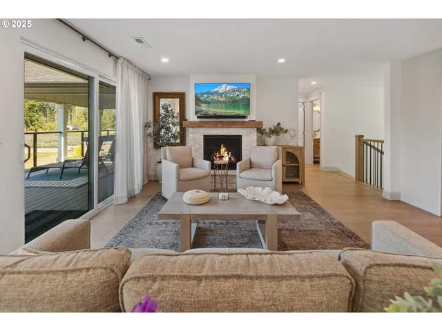 a living room with furniture a fireplace and a large window