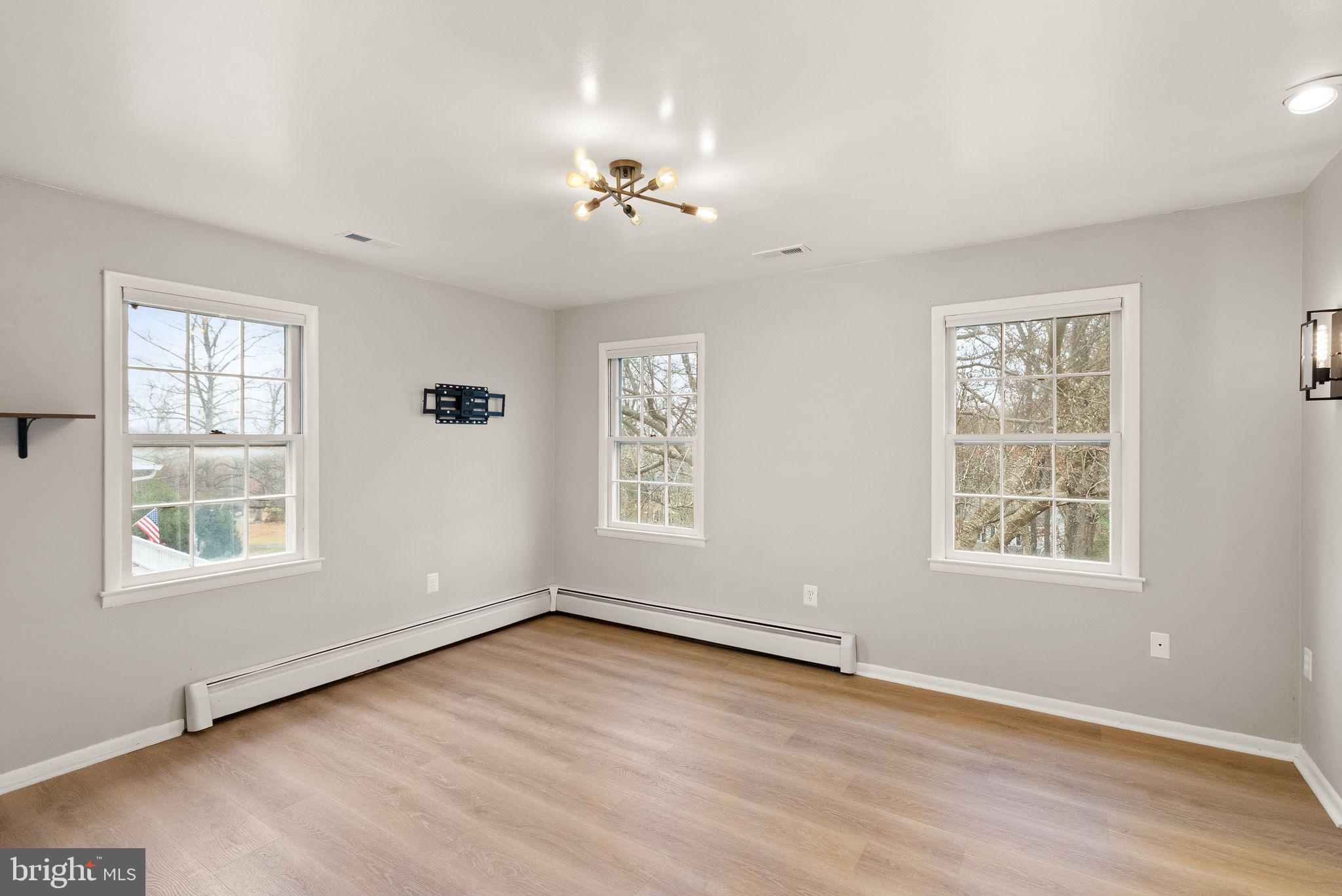 6738 Kelly Road Warrenton, VA 20187 - Photo 15 of 55 an empty room with wooden floor chandelier and windows