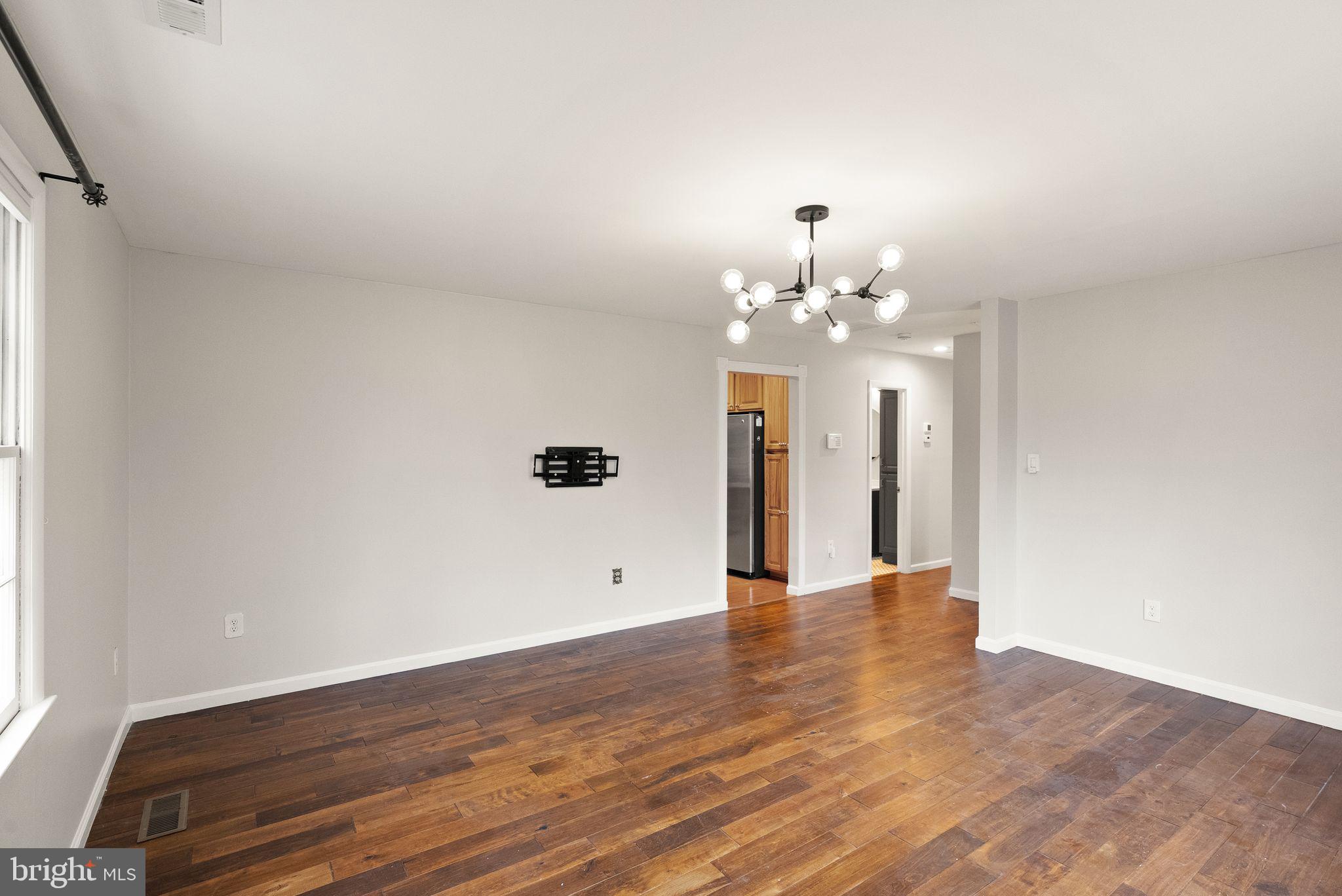 6738 Kelly Road Warrenton, VA 20187 - Photo 8 of 55 a view of an empty room with wooden floor and a window