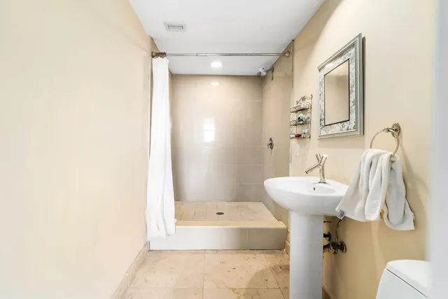 a living room with furniture tv and floor to ceiling windows