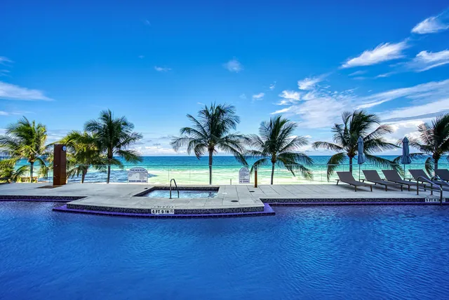 a living room with fireplace furniture and floor to ceiling windows