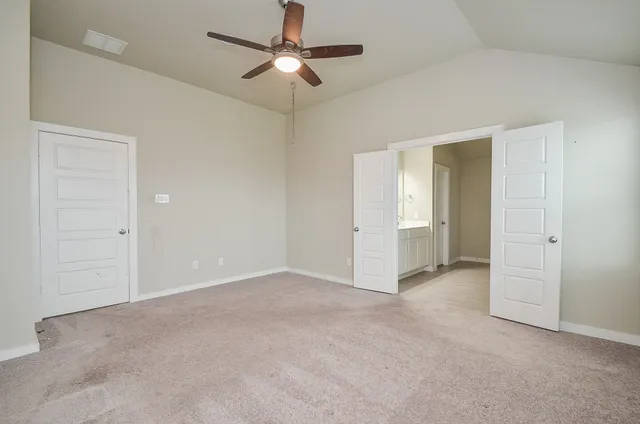 an empty room with ceiling fan and entryway
