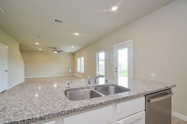 a kitchen with granite countertop a sink and a large mirror