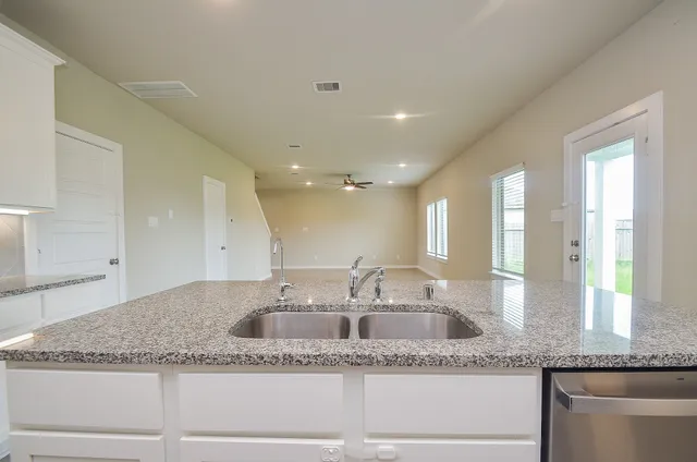 a bathroom with a granite countertop sink and a large mirror