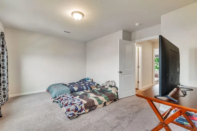 a bedroom with bed and a flat screen tv