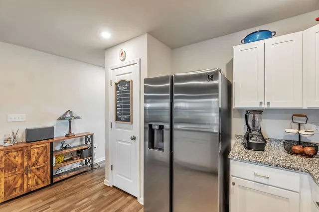 a kitchen with granite countertop stainless steel appliances a refrigerator a sink and cabinets