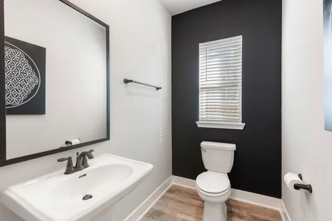 a bathroom with a toilet a sink and a window