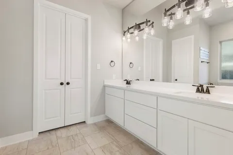 a bathroom with double sink and a mirror