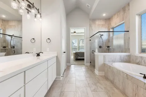 a bathroom with a tub a sink and mirror