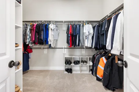 a view of walk in closet with clothes and shoes