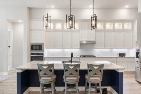 a kitchen with stainless steel appliances granite countertop a sink and a refrigerator