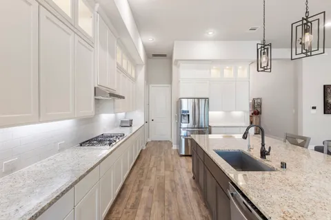 a kitchen with stainless steel appliances granite countertop a sink stove and refrigerator