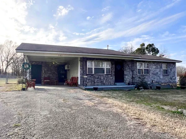 a view of a house with a patio and a yard