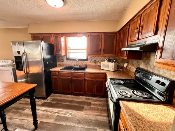 a kitchen with stainless steel appliances granite countertop a stove a refrigerator and a stove