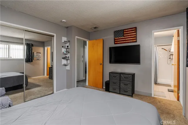 a bedroom with a bed and a flat screen tv