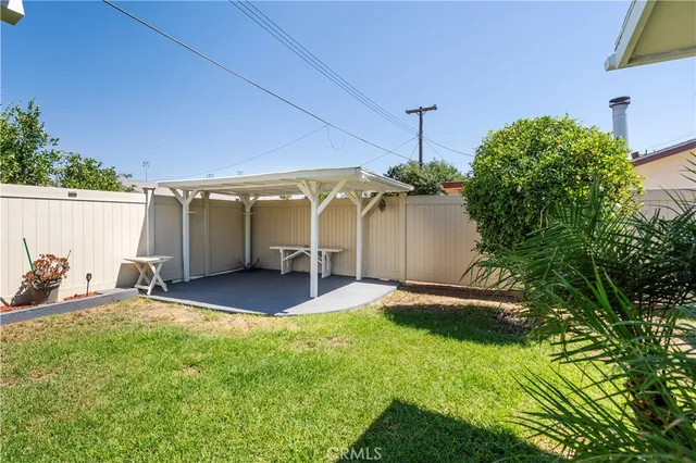 a view of a house with backyard and a tree