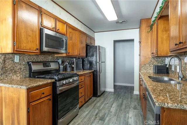 a kitchen with stainless steel appliances granite countertop a stove a sink and a microwave