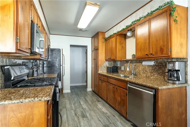 a kitchen with stainless steel appliances granite countertop a stove a sink and a refrigerator