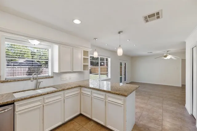 a kitchen with granite countertop a sink and a window