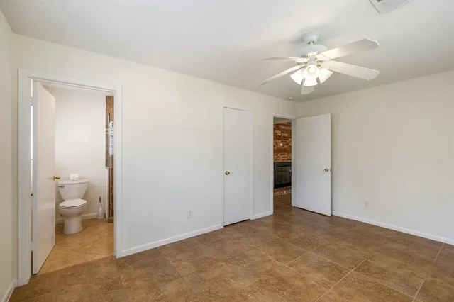 a view of a room with a chandelier fan and a bathroom