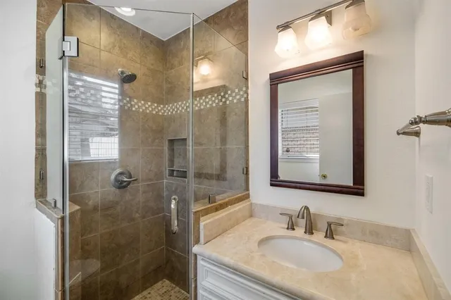 a bathroom with a sink shower and a mirror