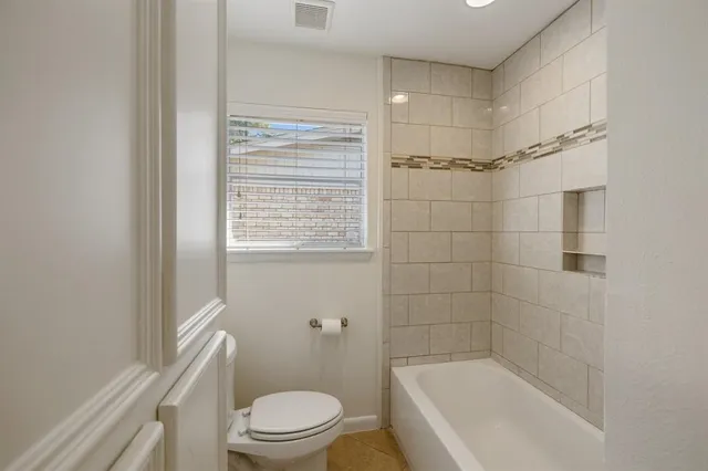 a bathroom with a shower a bathtub and toilet