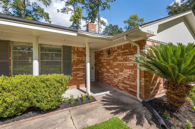 a yellow house with trees in front of it