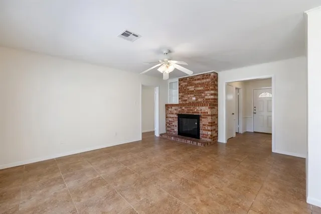 a view of an empty room with a fireplace and a window